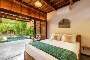 吉利阿尔Rimba Villas Gili Air的一间卧室设有一张床和一个游泳池