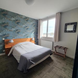 克朗HOTEL RESTAURANT Crêperie du Château的一间卧室设有一张床和蓝色的墙壁