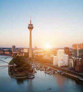 杜塞尔多夫MAX Hotel Düsseldorf Self-Check-in的享有塔楼和河流的城市美景