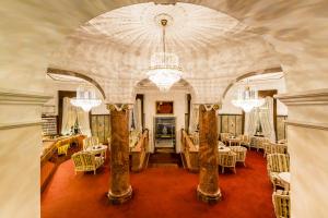 梅拉诺Grand Hotel Bellevue - adults only的大型客房配有桌椅和吊灯。