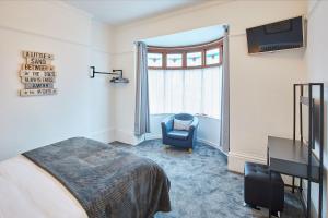 惠特比Apartment 1 - Khyber Lodge Apartments的卧室配有床、椅子和窗户。
