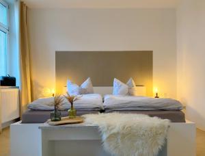 科斯维格Elbnahe Ferienwohnung mit 2 Schlafzimmern的一间卧室配有两张带白色枕头和桌子的床。