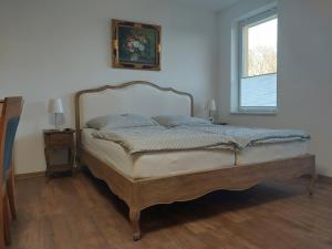 Usedom TownJennys Hofladen的一间卧室配有一张木框床和窗户。