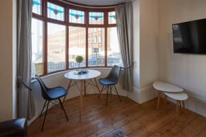 惠特比Apartment 2, Khyber Lodge Apartment Whitby的客房设有桌椅和窗户。