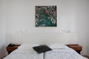 马斯蒂查里Sea Breeze Hotel的一间卧室设有两张床,墙上挂着一幅画