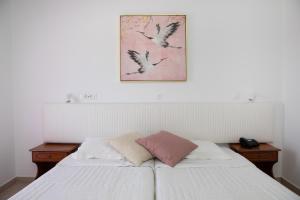 马斯蒂查里Sea Breeze Hotel的一间卧室配有两张床,并拥有鸟儿的照片