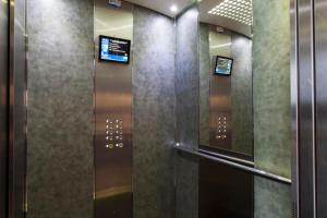 Premia de DaltParc Güell GF的墙上有两台显示器的建筑物内的电梯