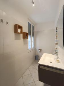 瓦拉泽Blackstone Apartment的白色的浴室设有水槽和窗户。