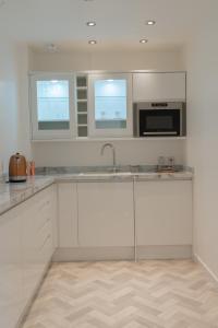 阿赫纳欣勒吉湾小屋酒店的白色的厨房配有水槽和微波炉