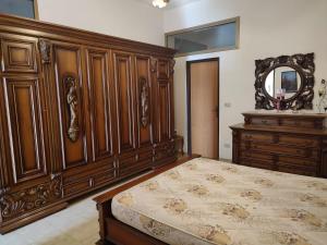 雷焦卡拉布里亚Campolo Apartment的一间卧室配有木床和镜子