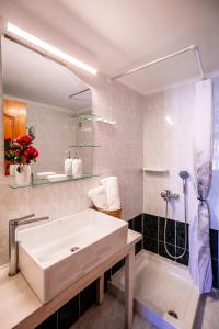 阿凯松Villy Suites的浴室配有大型白色浴缸和水槽