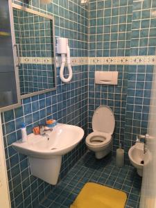 兰佩杜萨Attico sul Porto Vecchio - Lampedusa的蓝色瓷砖浴室设有卫生间和水槽