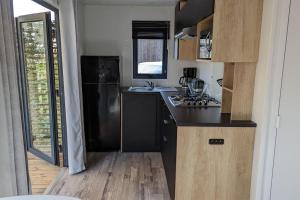 比斯卡罗斯Mobil-home Camping Mayotte 5*的厨房配有黑色冰箱和水槽
