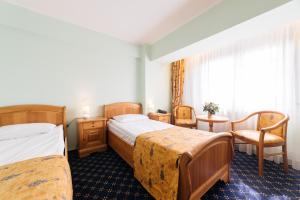 古拉哈莫卢洛伊德蒙特布科维纳俱乐部贝斯特韦斯特酒店的酒店客房带两张床和一张桌子以及椅子。