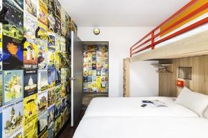 奥尔日河畔埃皮奈hotelF1 Epinay sur Orge的一间卧室配有一张床和一堵漫画墙