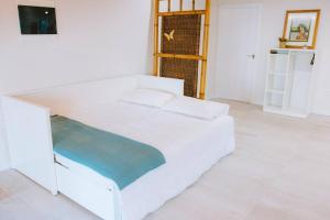 伊科德洛斯维诺斯Casita Gopal的白色的卧室配有白色的床和电视。