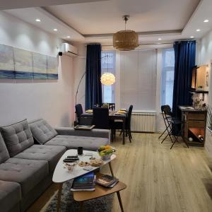 布加勒斯特Color Apartments Corneliu Coposu 1A street的客厅配有沙发和桌子