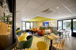 奥朗日Campanile Orange A7/ A9的餐厅设有桌椅和沙发。