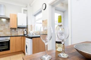 达灵顿Comfy & Homely Ideal for Families & Contractors的桌子上放有一瓶葡萄酒和两杯酒