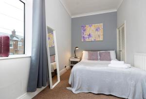 达灵顿Comfy & Homely Ideal for Families & Contractors的卧室配有白色的床和镜子