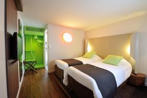 奥朗日Campanile Orange A7/ A9的酒店客房设有两张床和一台平面电视。