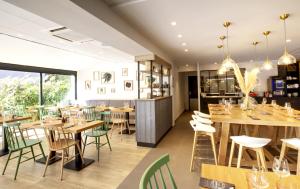 奥朗日Campanile Orange A7/ A9的餐厅设有木桌和绿色椅子