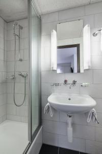 因特拉肯奥尔夫恩酒店的白色的浴室设有水槽和淋浴。