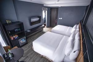 高平La Maison Boutique Hotel的卧室配有白色的床和电视