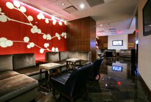阿林顿克里斯特尔城里根国家机场凯悦酒店的餐厅设有长沙发和桌子,拥有红色的墙壁