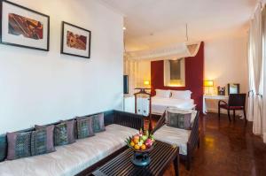 琅勃拉邦Angsana Maison Souvannaphoum Hotel的酒店客房设有一张沙发和一张床