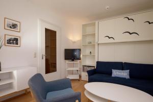 博尔滕哈根Dünenblick Wohnung 17的客厅配有蓝色的沙发和电视