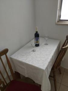 尼亚卢卡Apartman Bačić的一张桌子,上面放着一瓶葡萄酒和两杯酒杯