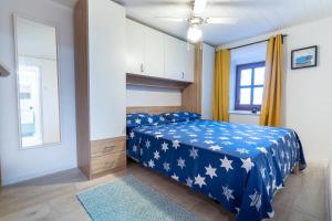 斯塔拉巴斯卡Holiday House Nova的一间卧室配有蓝色的床,上面有白色的星星