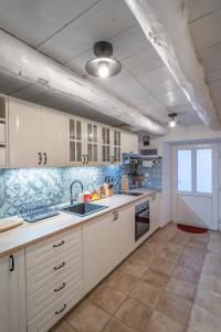 斯塔拉巴斯卡Holiday House Nova的厨房配有白色橱柜和水槽