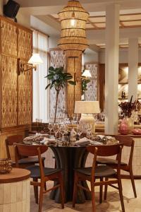 哥本哈根Grand Joanne的一间带桌椅和吊灯的用餐室