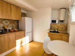 特乌拉达Happy holidays Moraira Apartment的厨房配有桌子和白色冰箱。