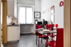 米兰C Studio - Design Bilo Suite -M3- 8 min dal Duomo的厨房以及带桌子和红色椅子的用餐室。