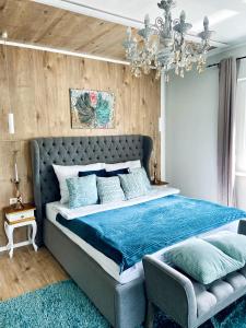 鲍洛通拜雷尼IrányBerény Rezidencia的一间卧室配有一张带蓝色床单和吊灯的大床