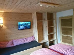 菲根Beautiful holiday home in a stunning location with sauna的小房间设有床铺和墙上的电视