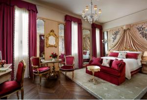 威尼斯The Gritti Palace, a Luxury Collection Hotel, Venice的一间卧室配有一张床和一张红色的沙发