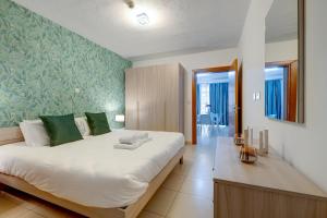 斯利马Sliema Tigne Suites的卧室配有一张白色大床和绿色壁纸