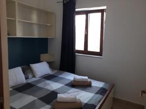 SavarApartmani Zdenka Savar-Maslina的一间卧室配有一张带两条毛巾的可拉式床