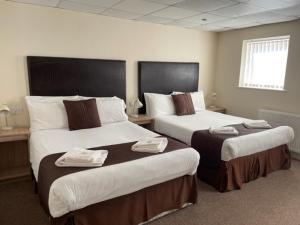 布莱克浦Stuart hotel的酒店客房,配有两张带毛巾的床