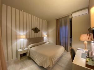 奥维多Casa Vèra Affittacamere的酒店客房配有一张床、一张书桌和一张书桌。