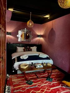马拉喀什Riad Alena的一间卧室配有一张大床和一张桌子