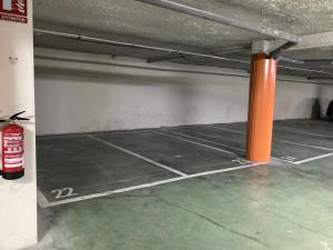 马德里Apartamento grande, 2 dormitorios, garaje gratis的一个带网球场的停车库
