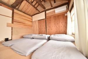 桐生市Dive INN Kiryu的木墙房间的一排床位