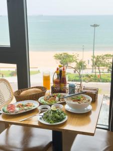 归仁HAKU Boutique Hotel Quy Nhơn的一张带食物盘的桌子,享有海景