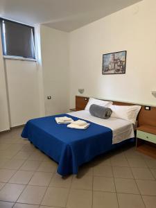 米兰默库里奥酒店的一间卧室配有一张带蓝色毯子的床