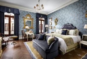 威尼斯The Gritti Palace, a Luxury Collection Hotel, Venice的卧室拥有蓝色的墙壁,配有一张床和一张沙发